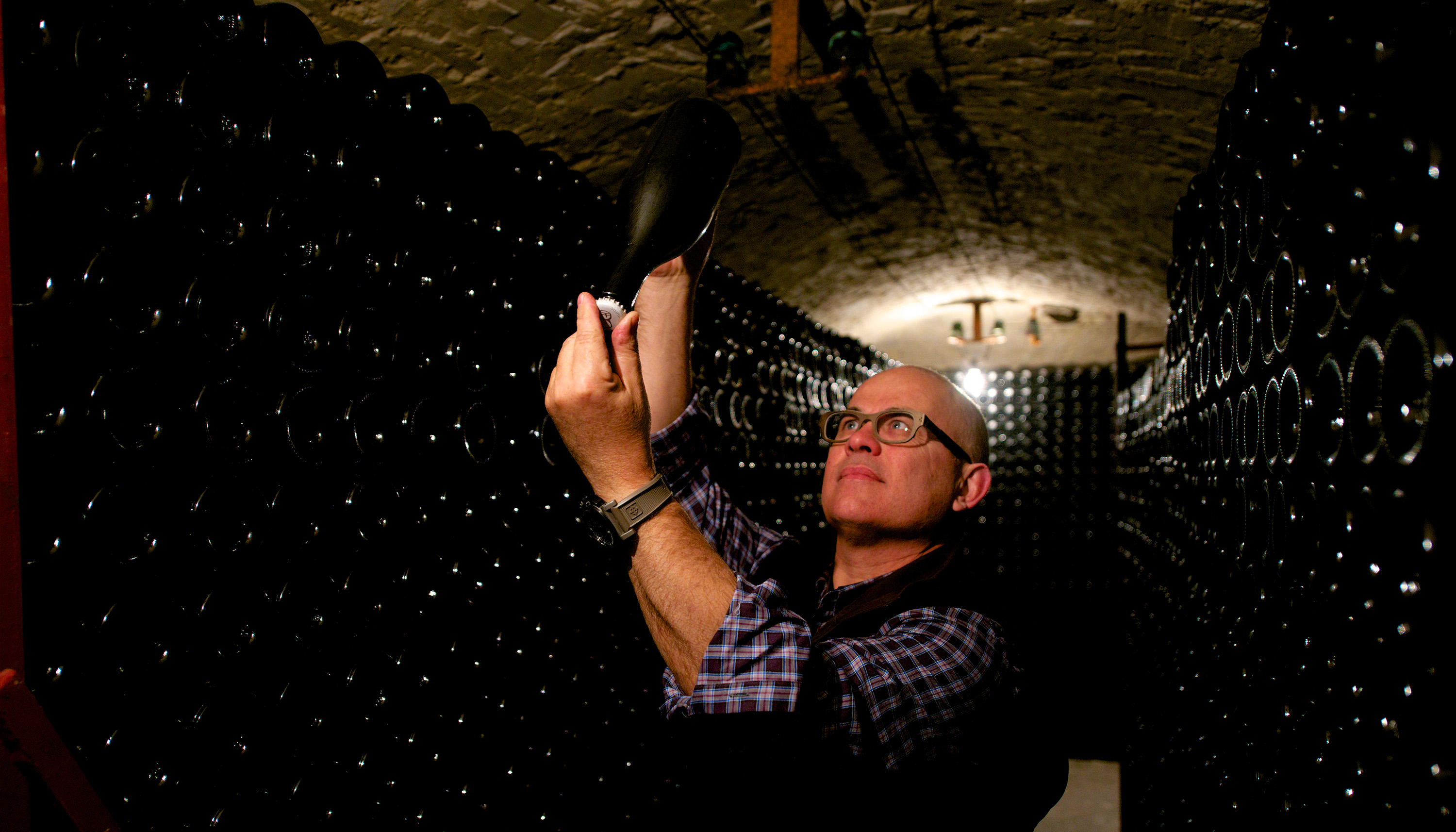 Eric Rodez begutachtet eine Flasche Champagner im Keller