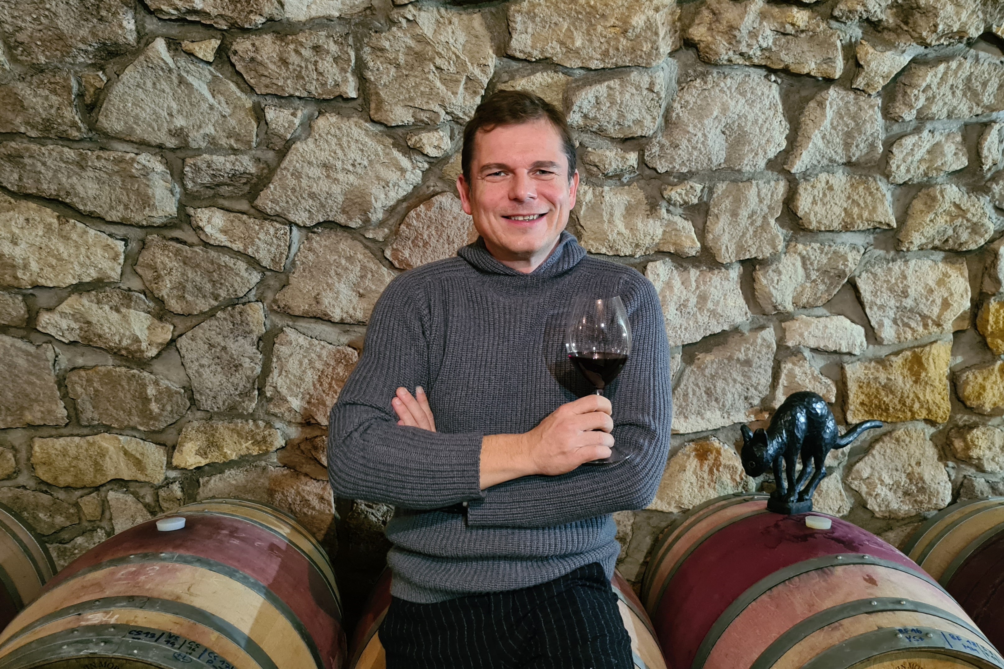 der Winzer des Weinguts mit einem Glas Rotwein