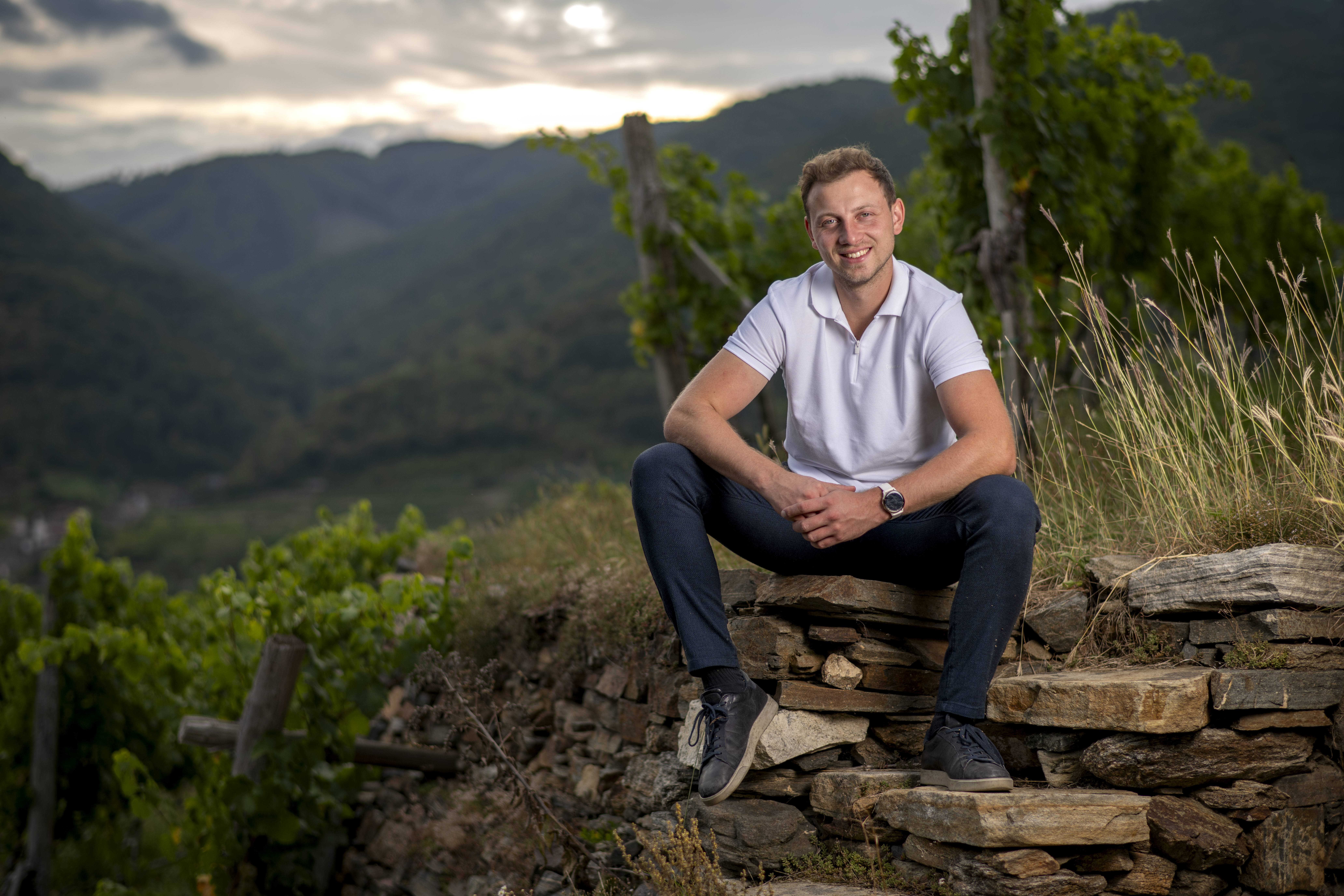 Walter Lahrnsteig sitzt auf einem Felsen in seinem Weingarten